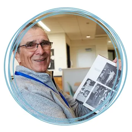 A St. Francis alumnus looks through a yearbook at Homecoming